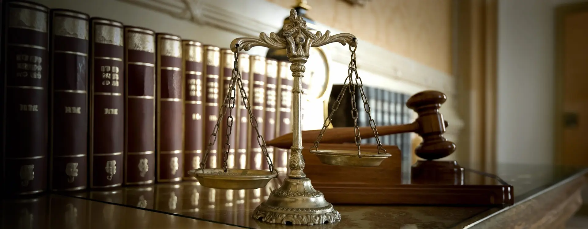 A close up of the scales of justice in front of some books