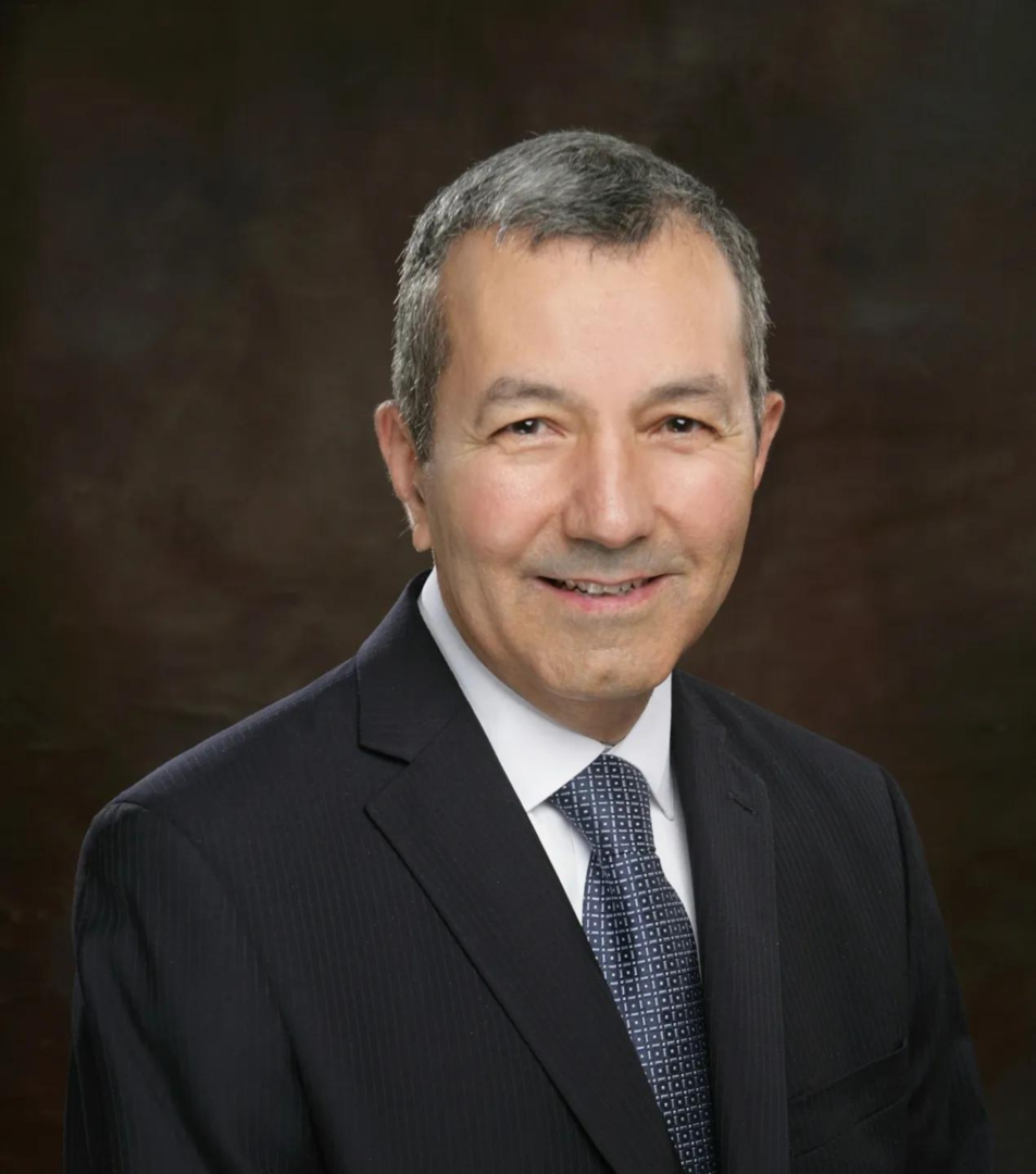 A man in suit and tie smiling for the camera.